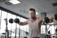 Dumbbell shoulder press adds size to the shoulders. (Photo via Pexels/Andrea Piacquadio)